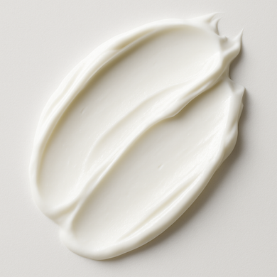 A swatch of white cream on a surface, representing the texture and consistency of the Aloha Glow SkinLuxe Face & Body Crème.